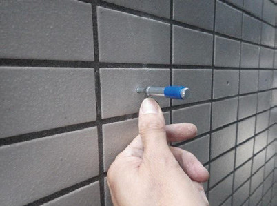 写真-11 孔の深さ確認 専用の確認棒を使用し,孔の深さと座掘り深さを確認する